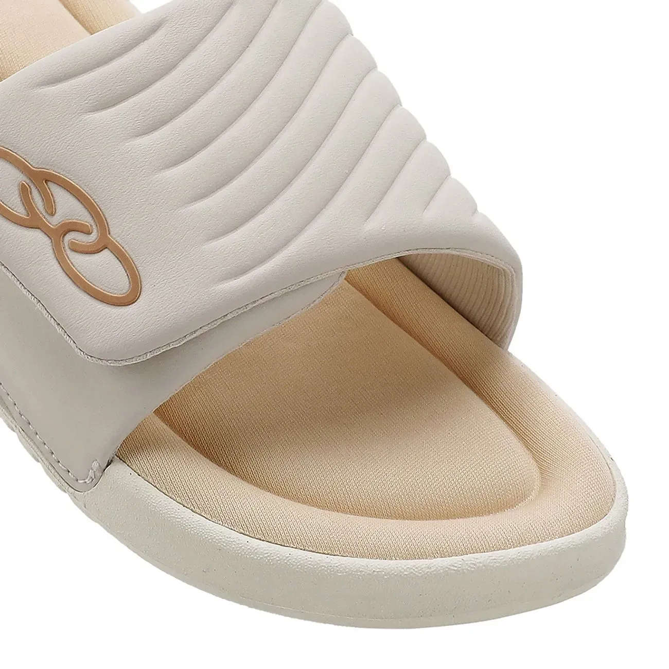 Close da tira acolchoada do chinelo Olympikus mostrando textura, ondulações e logo dourado
